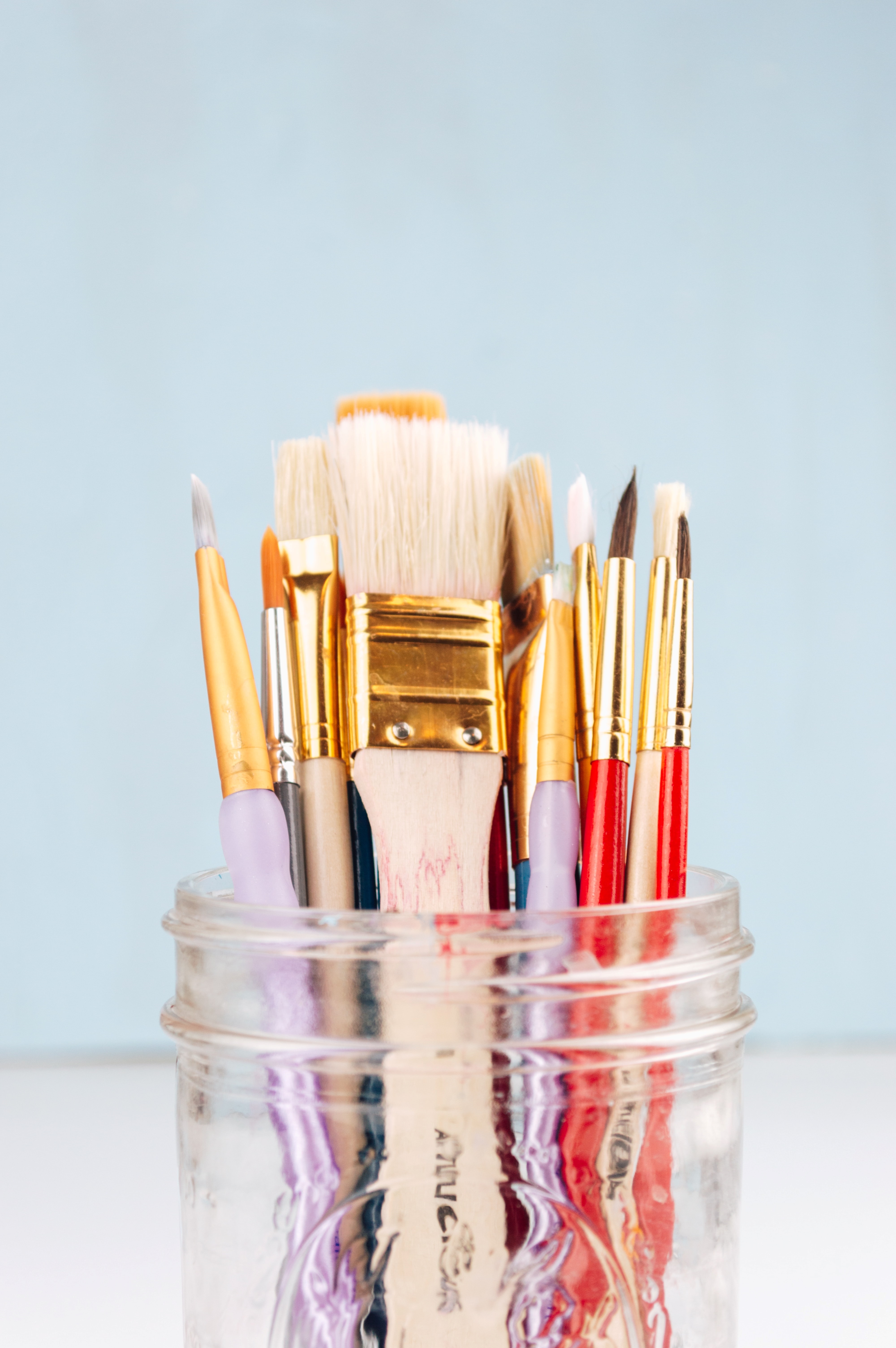 glass jar with paintbrushes of various sizes