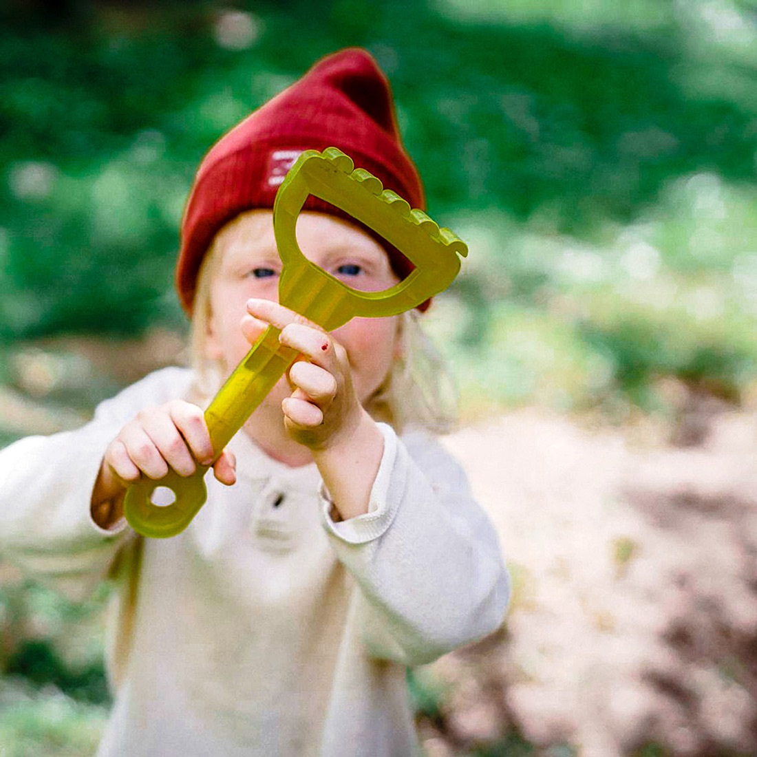 Child with a toy rake, digging for our Archeology 'Digs' event.