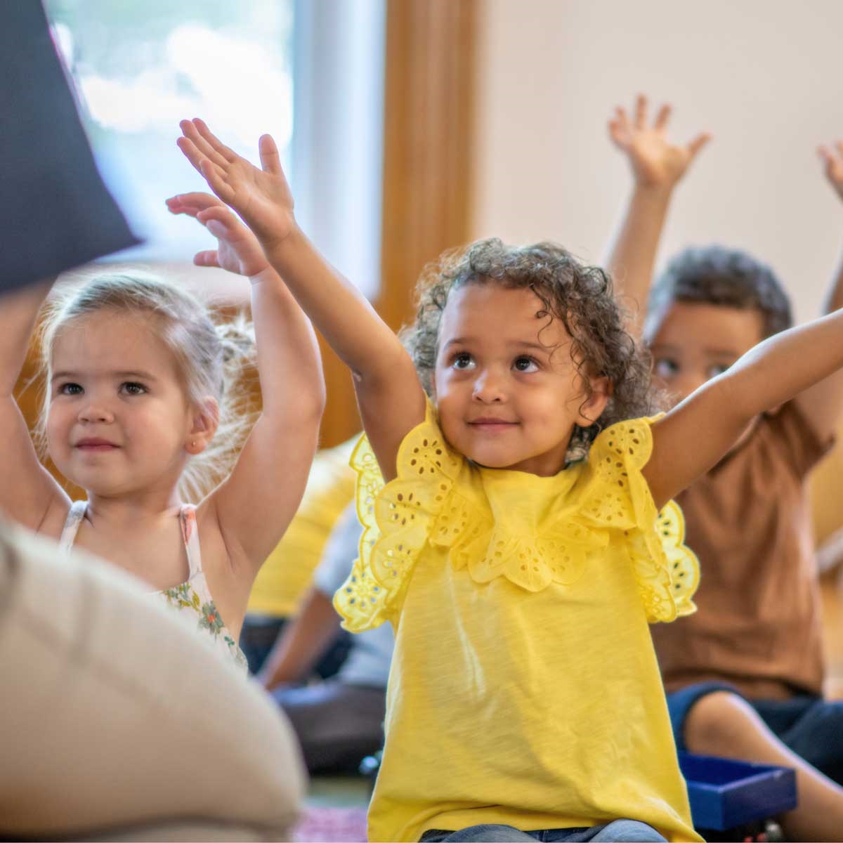 preschool child smiling with arms raised